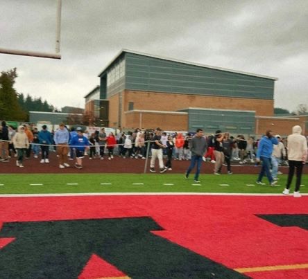 Picture of students evacuating the building onto the football field